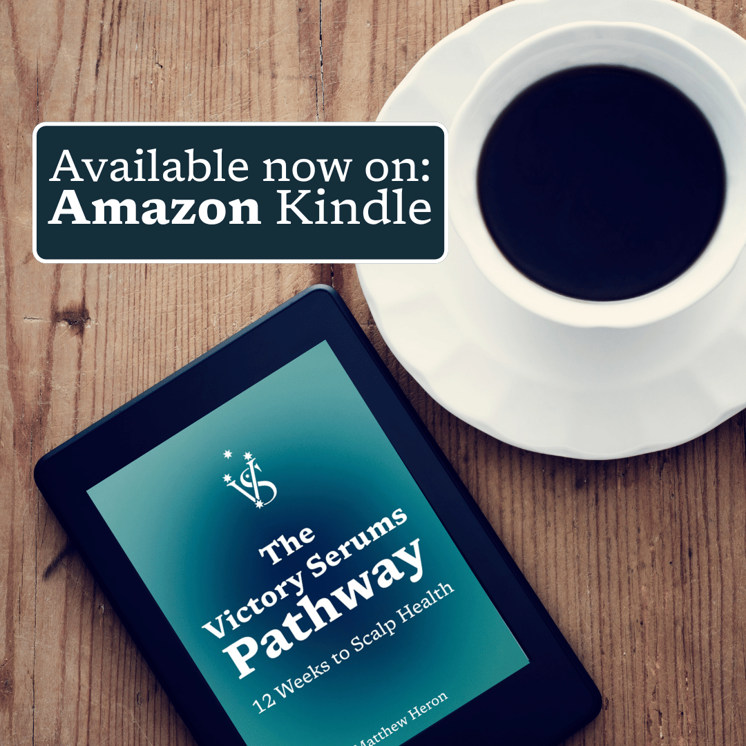 Kindle device displaying 'The Victory Serums Pathway' on a wooden surface with a cup of coffee.